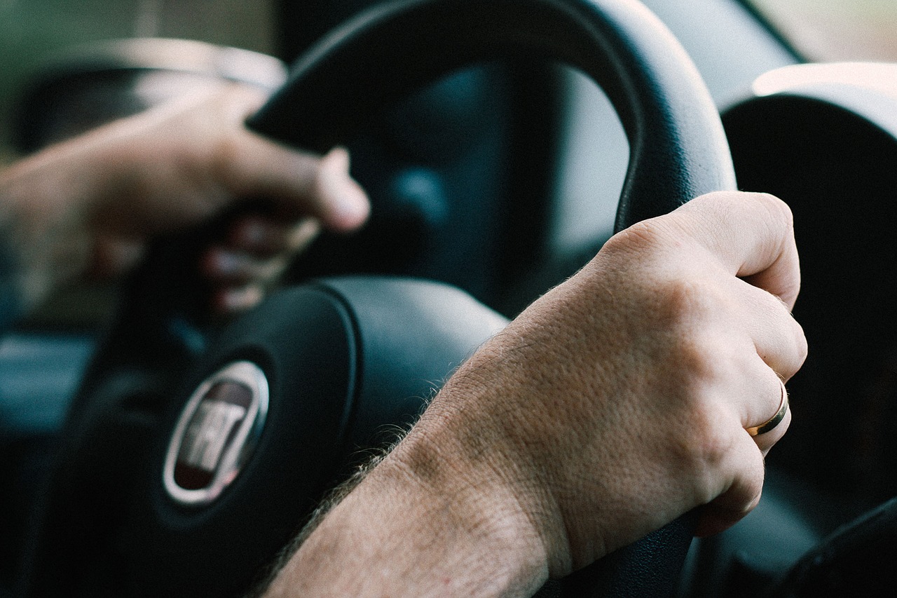 car hands on steering wheel