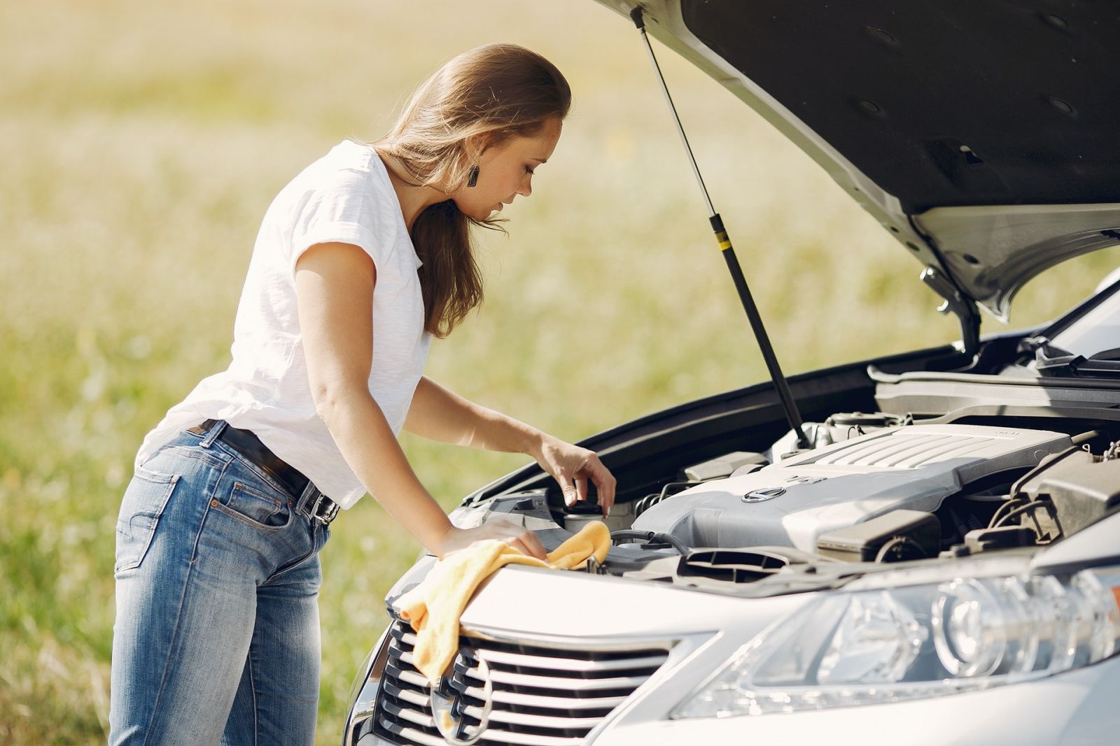 woman checking car engine and car battery