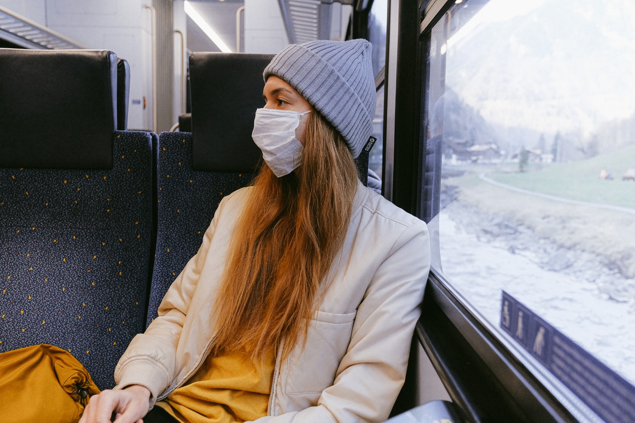 person in train wearing a surgical mask